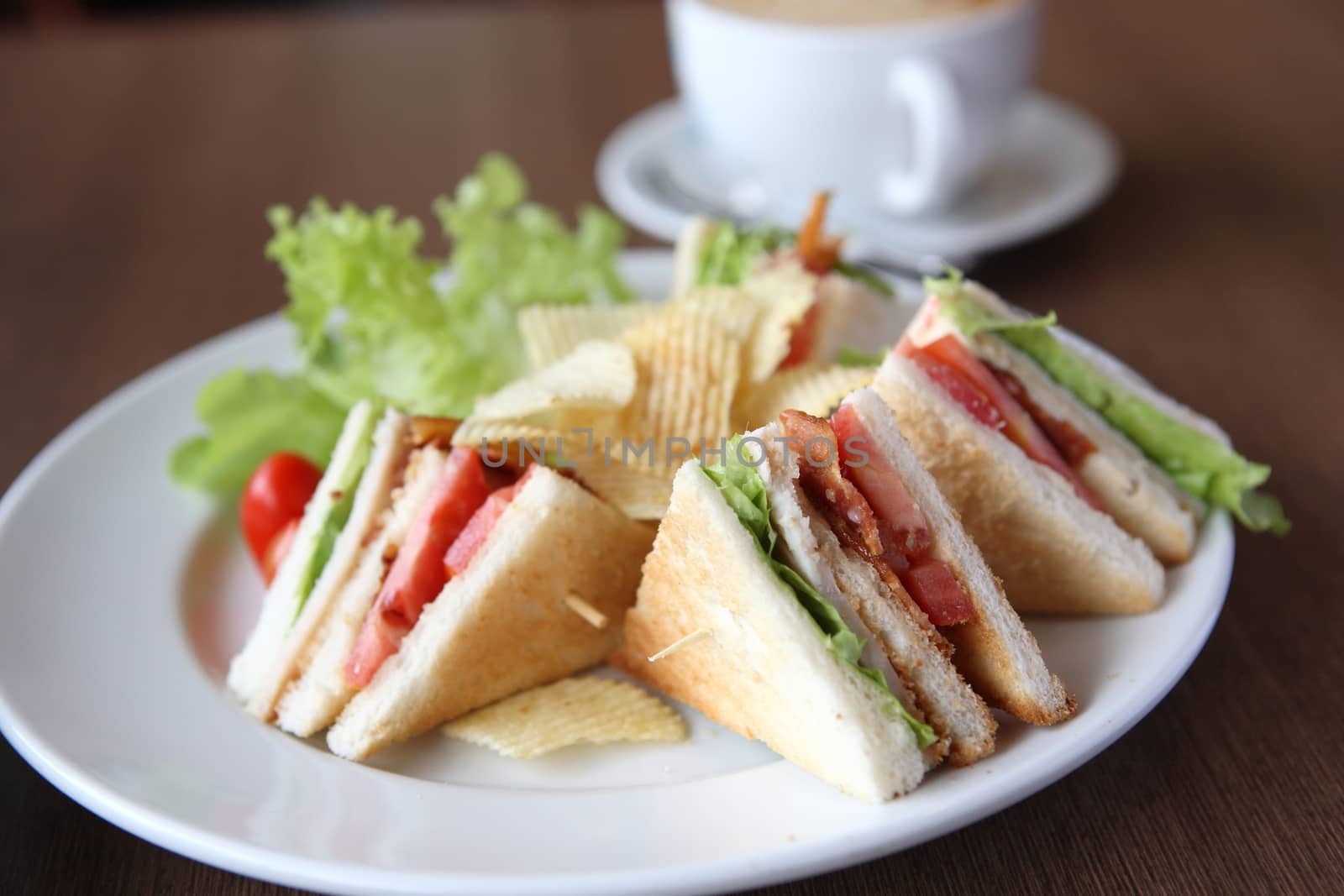 Club sandwich with coffee on wood background