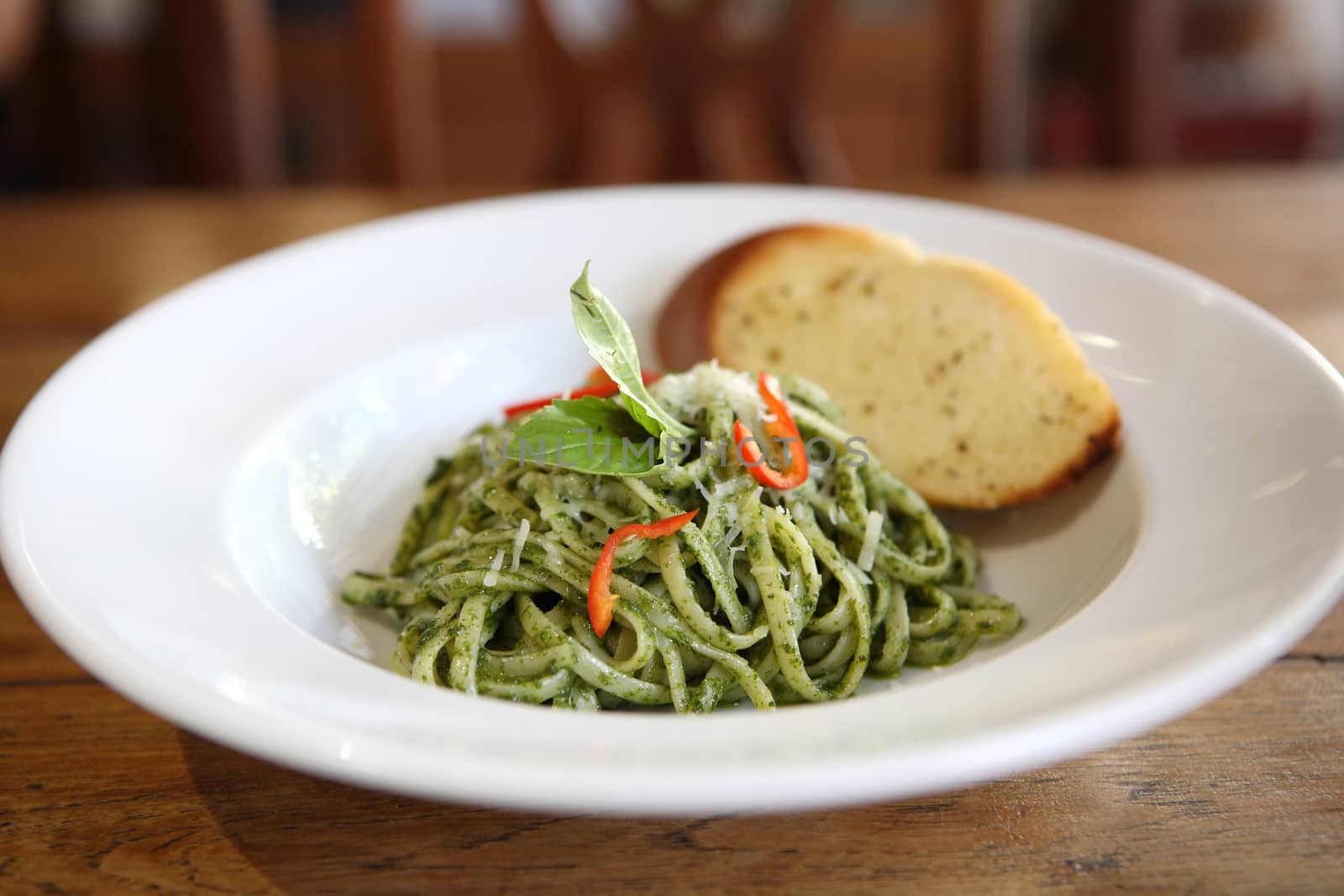 spaghetti with pesto sauce on wood background