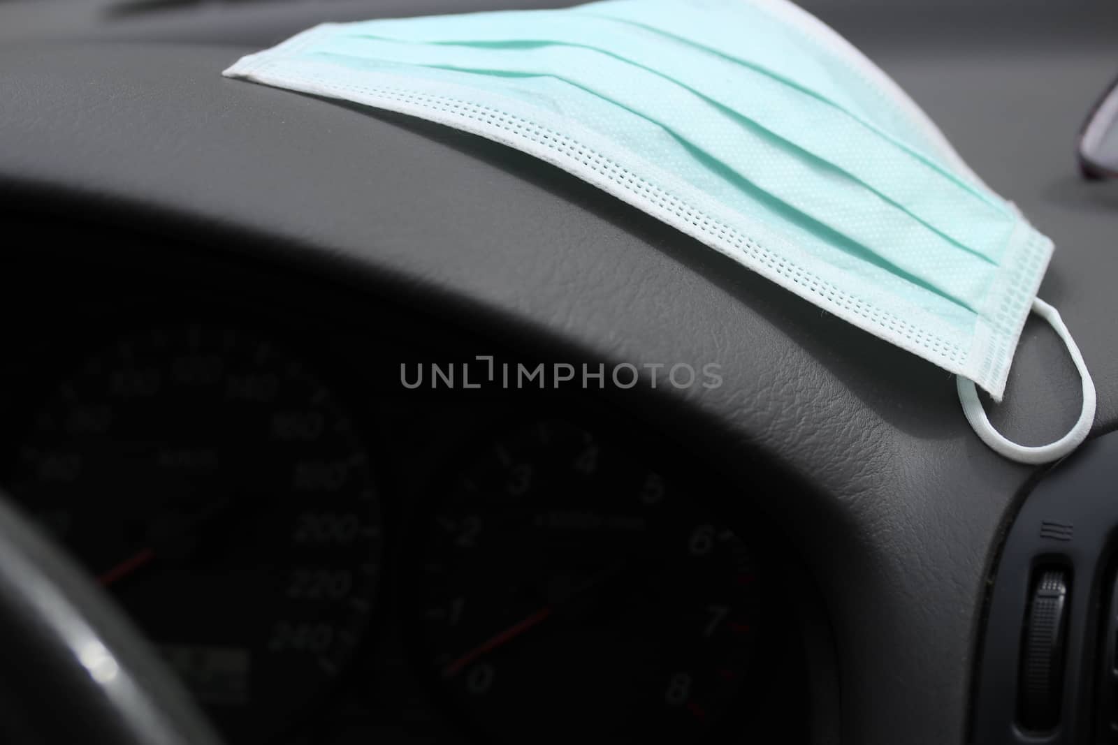 Protection face mask on the dashboard in the car