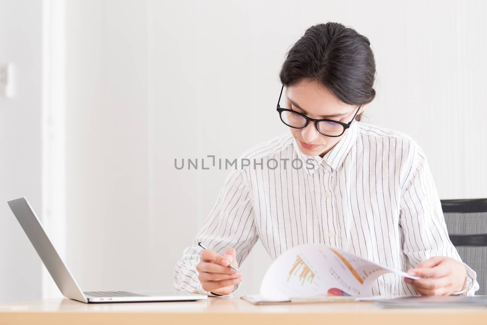 A businesswoman wearing glasses working with smiling and happine by animagesdesign
