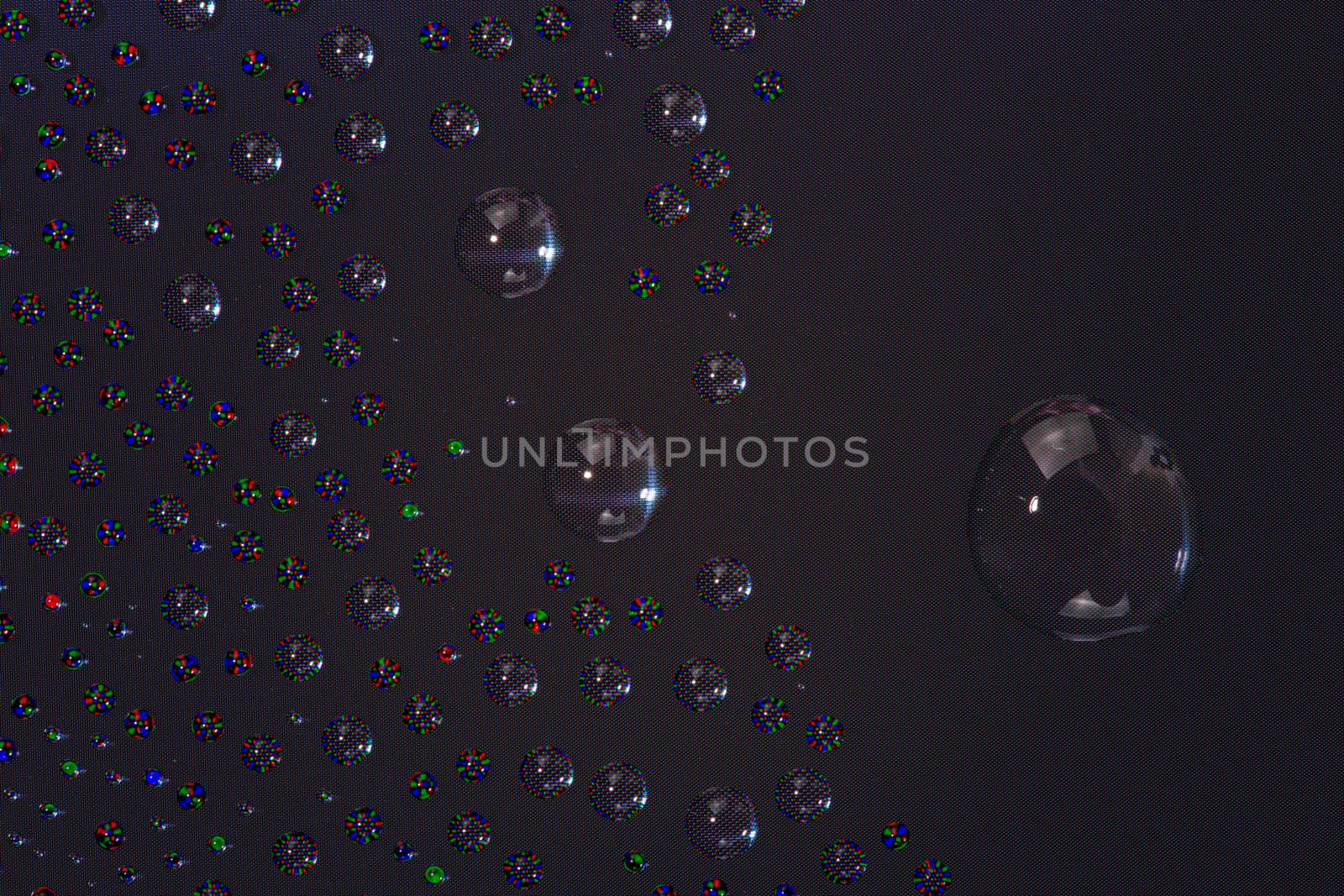 many small water drops on the surface of cellphone hydriphobic coated glass screen, close-up with selective focus and visible subpixel rgb triads