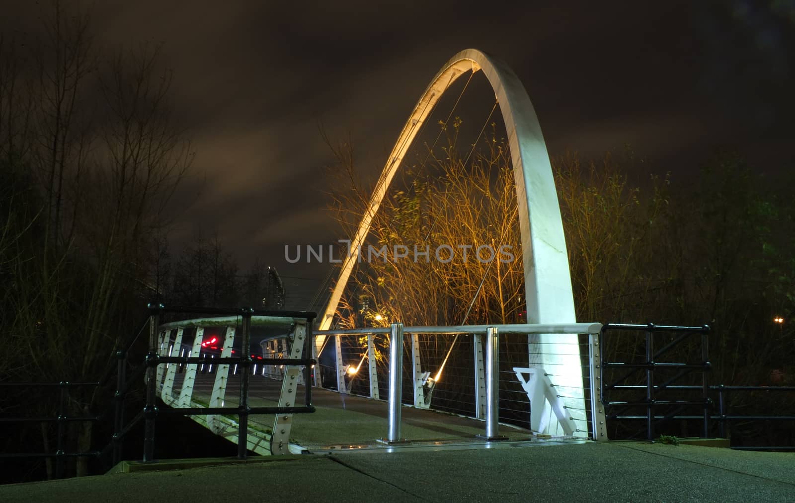 a pedestrian footbridge crossing the river aire in leeds illuminated at night