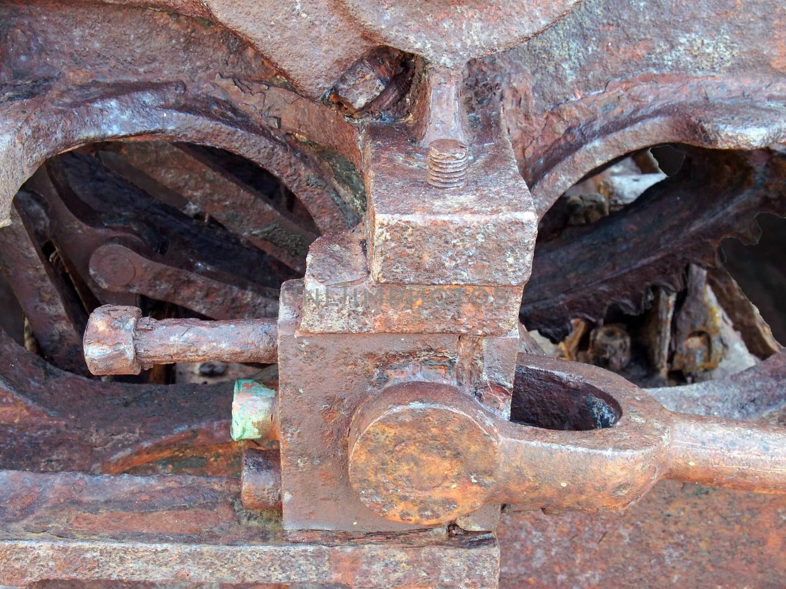 a close up of brown rusted threaded bolts and nuts on old corroded machinery