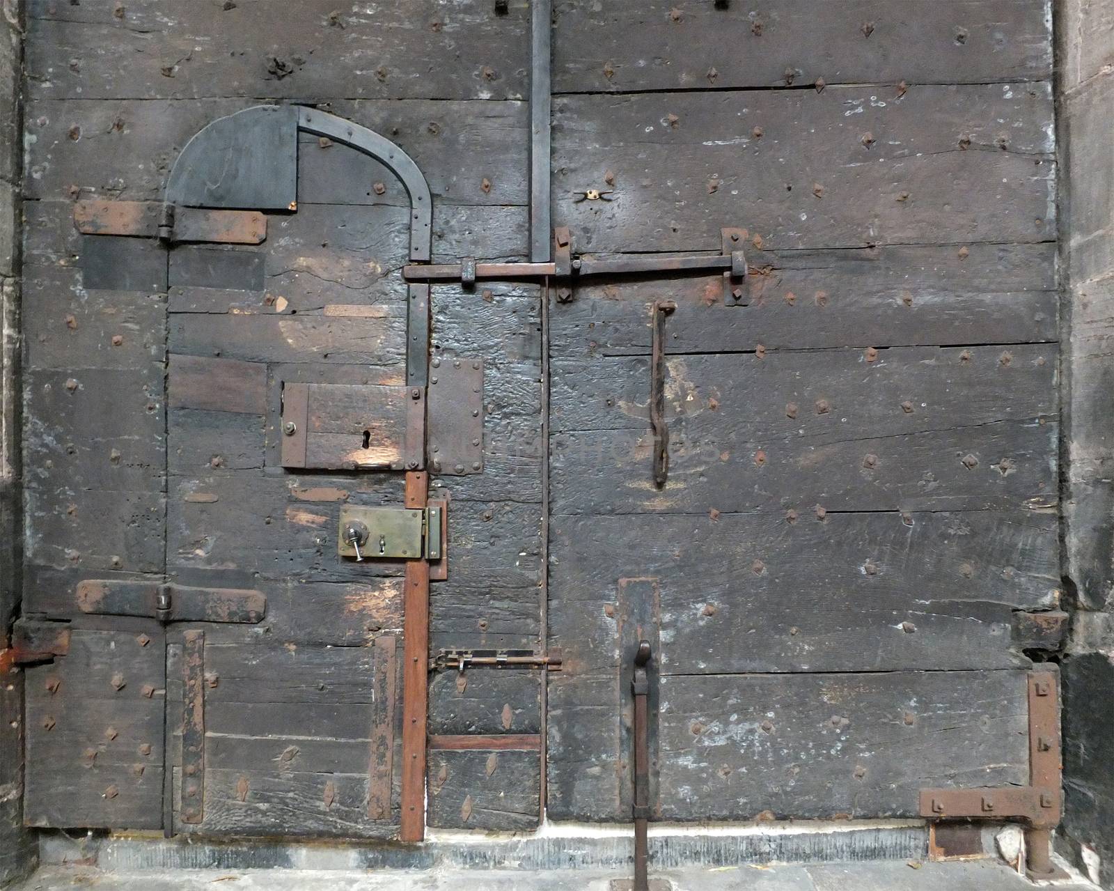 ancient black wooden medieval door with iron locks and bolts on chester cathedral