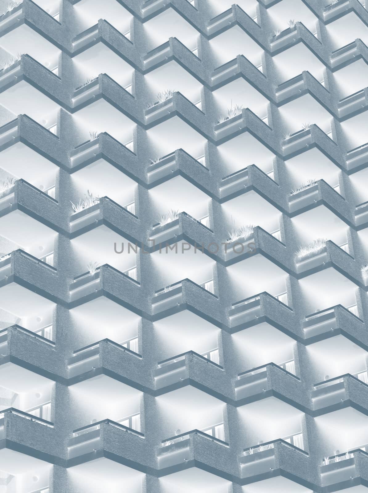 an abstract blue duotone image of large residential highrise building with geometric rows of balconies
