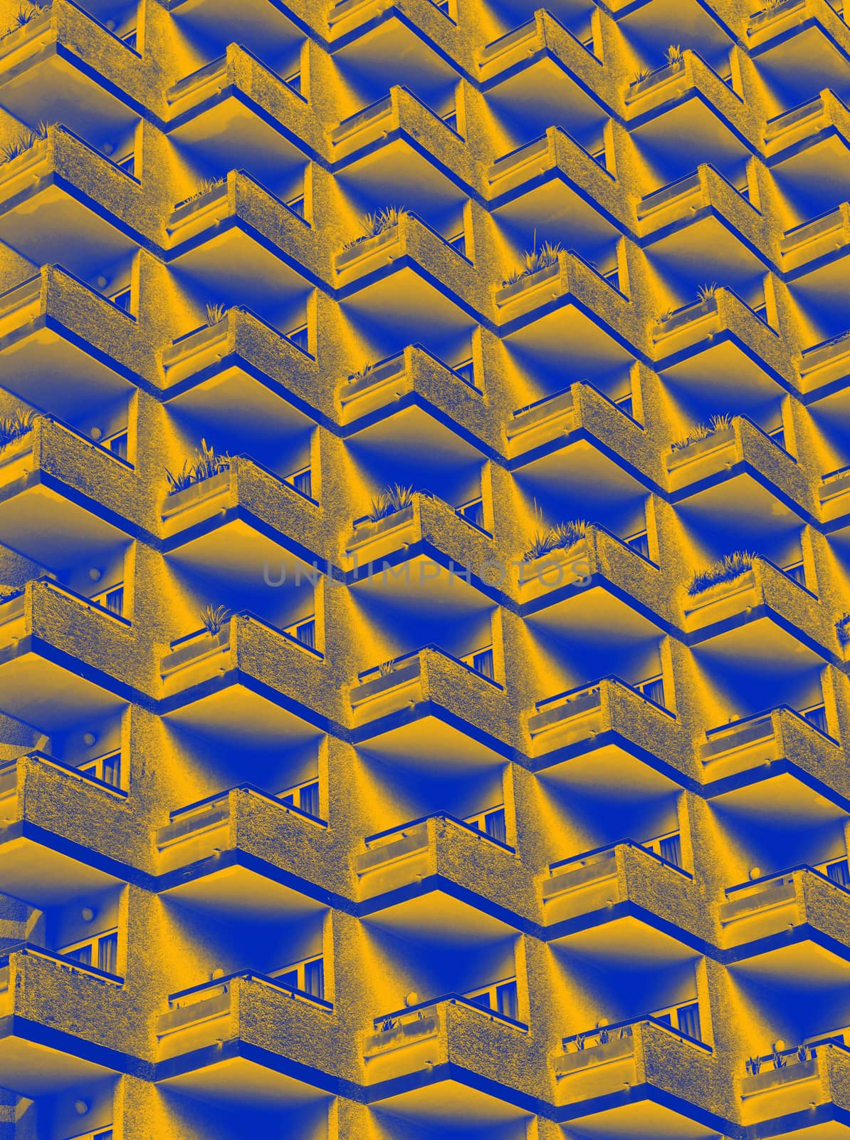 an abstract duotone yellow and blue image of large residential highrise building with geometric rows of balconies