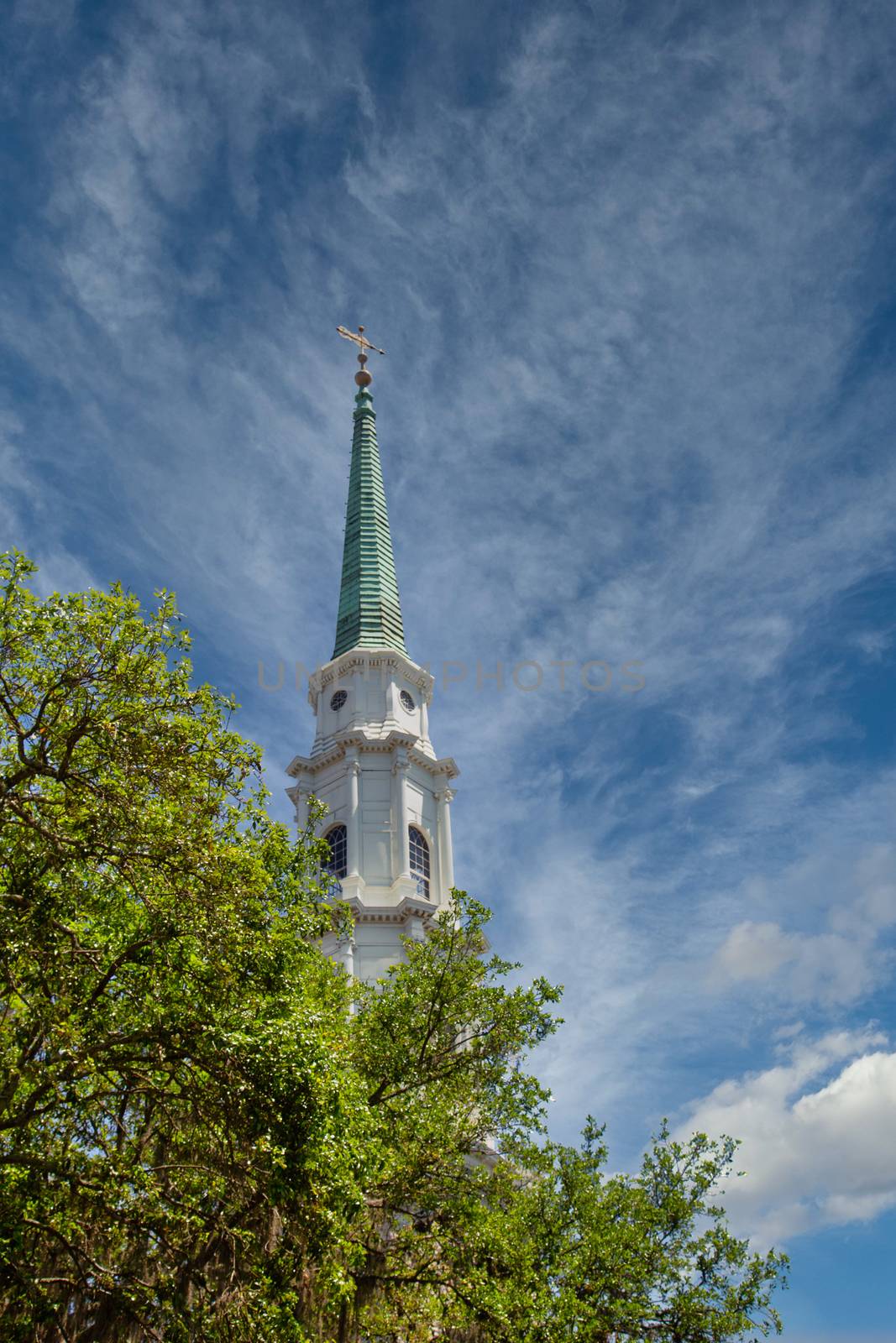 A church steeple rising into the sky beyond trees