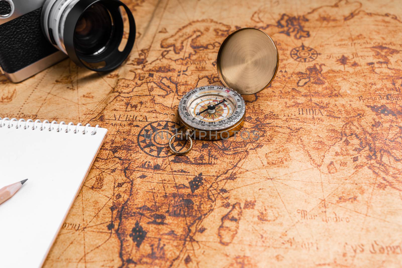 Vintage Compass and camera on map for travel planning