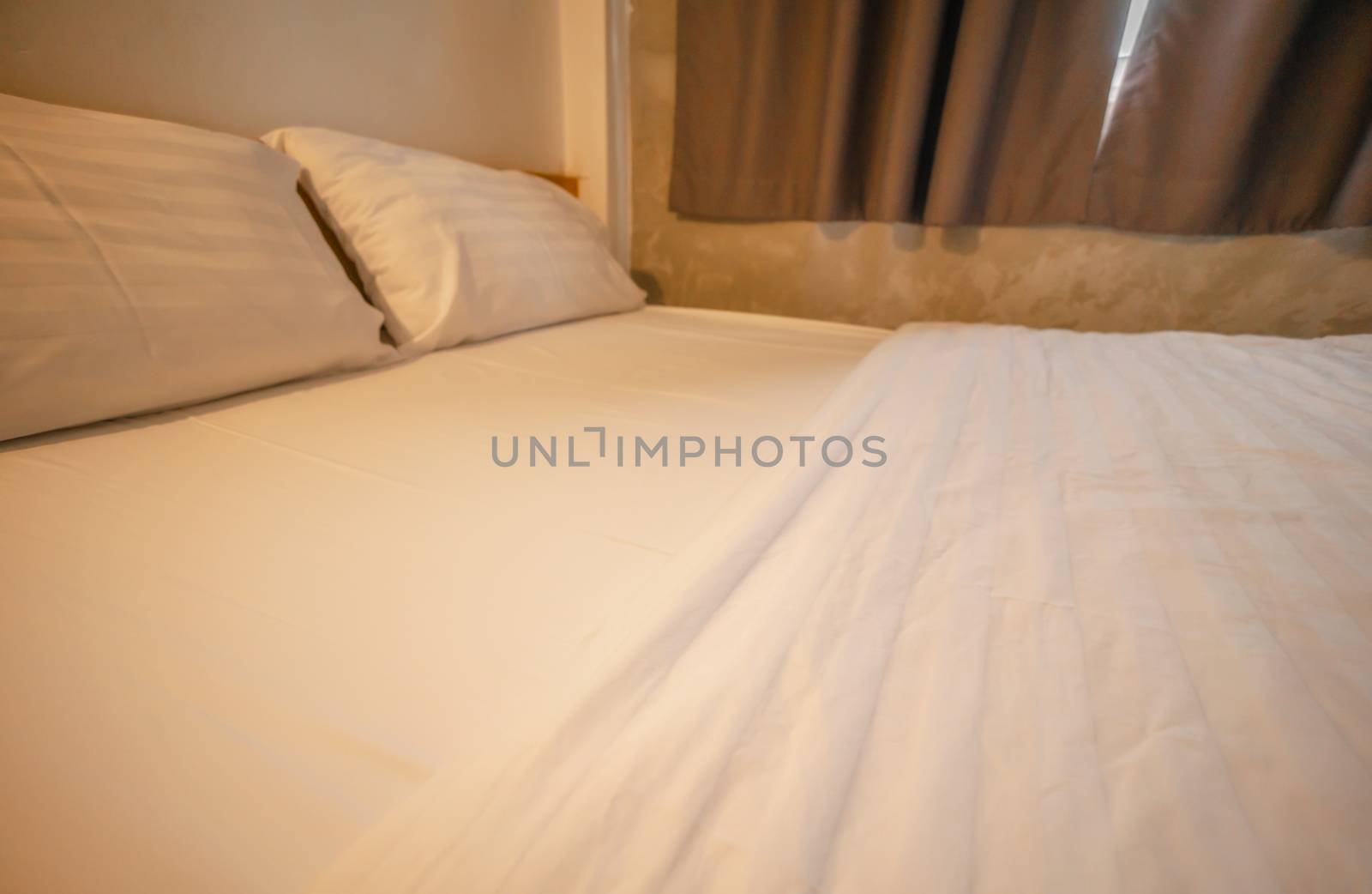 Blurred bedroom in hotel with warm light