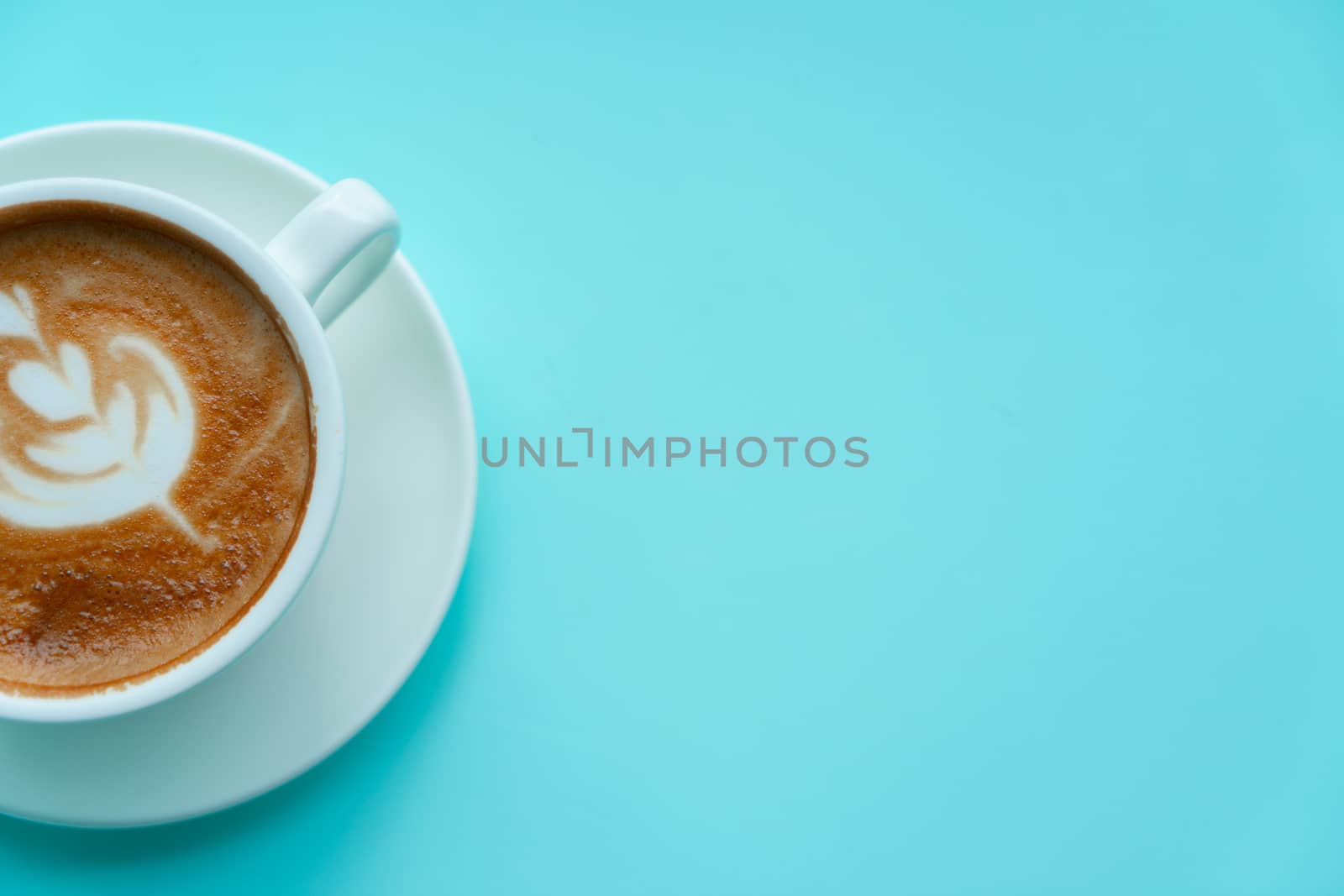 Hot coffee with late art on blue background