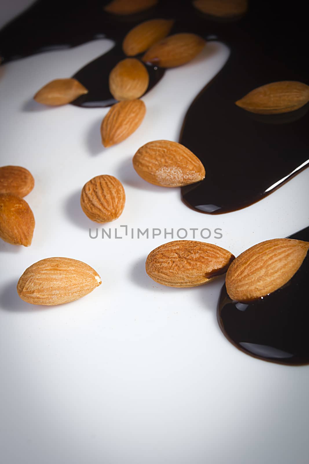 Almonds and melted chocolate on a white background