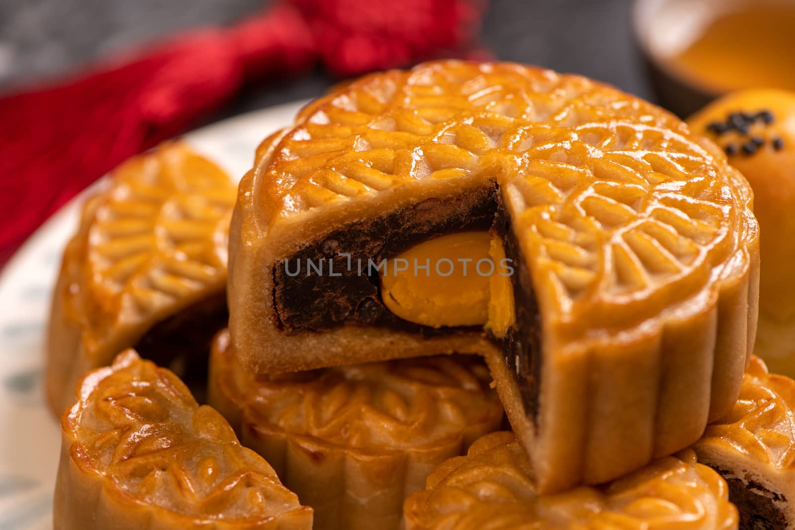 Tasty baked egg yolk pastry moon cake for Mid-Autumn Festival on black slate dark background. Chinese festive food concept, close up, copy space.