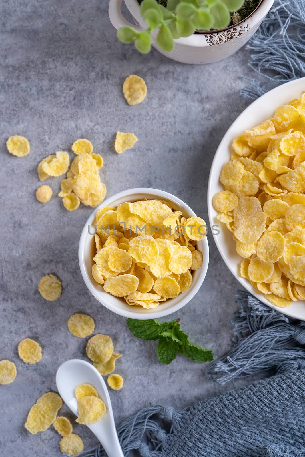 Corn flakes bowl sweets on gray cement background, top view flat lay layout design, fresh and healthy breakfast concept.