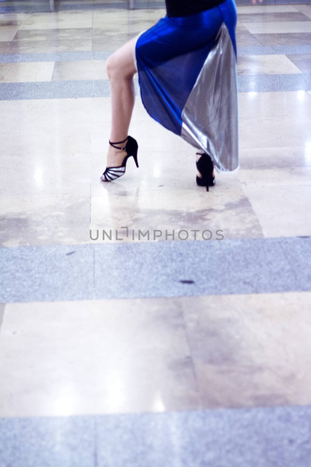 Legs of female dancer walking through a ballroom by GemaIbarra
