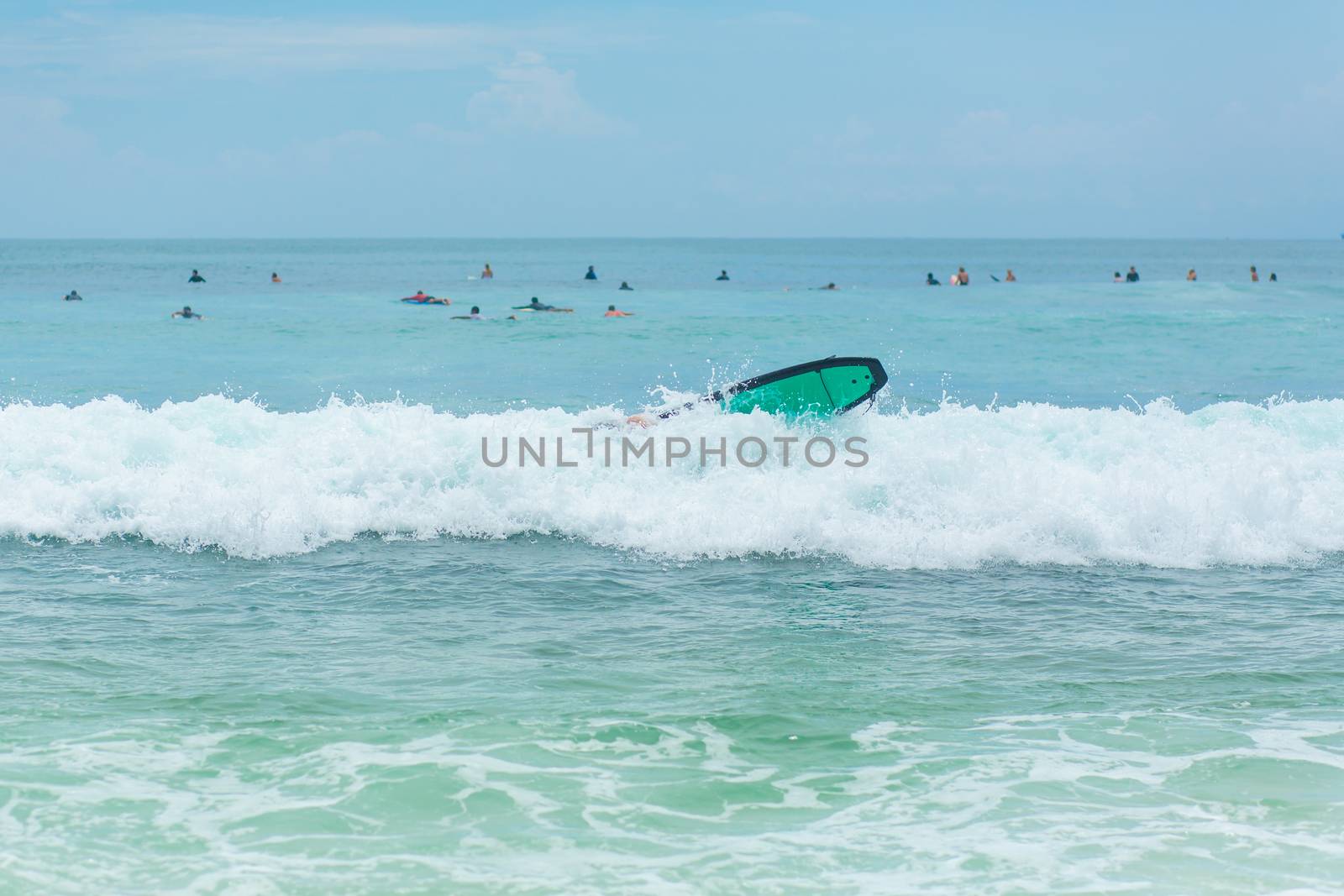 The guy is swimming on the surf board on the ocean. Healthy active lifestyle in summer vocation