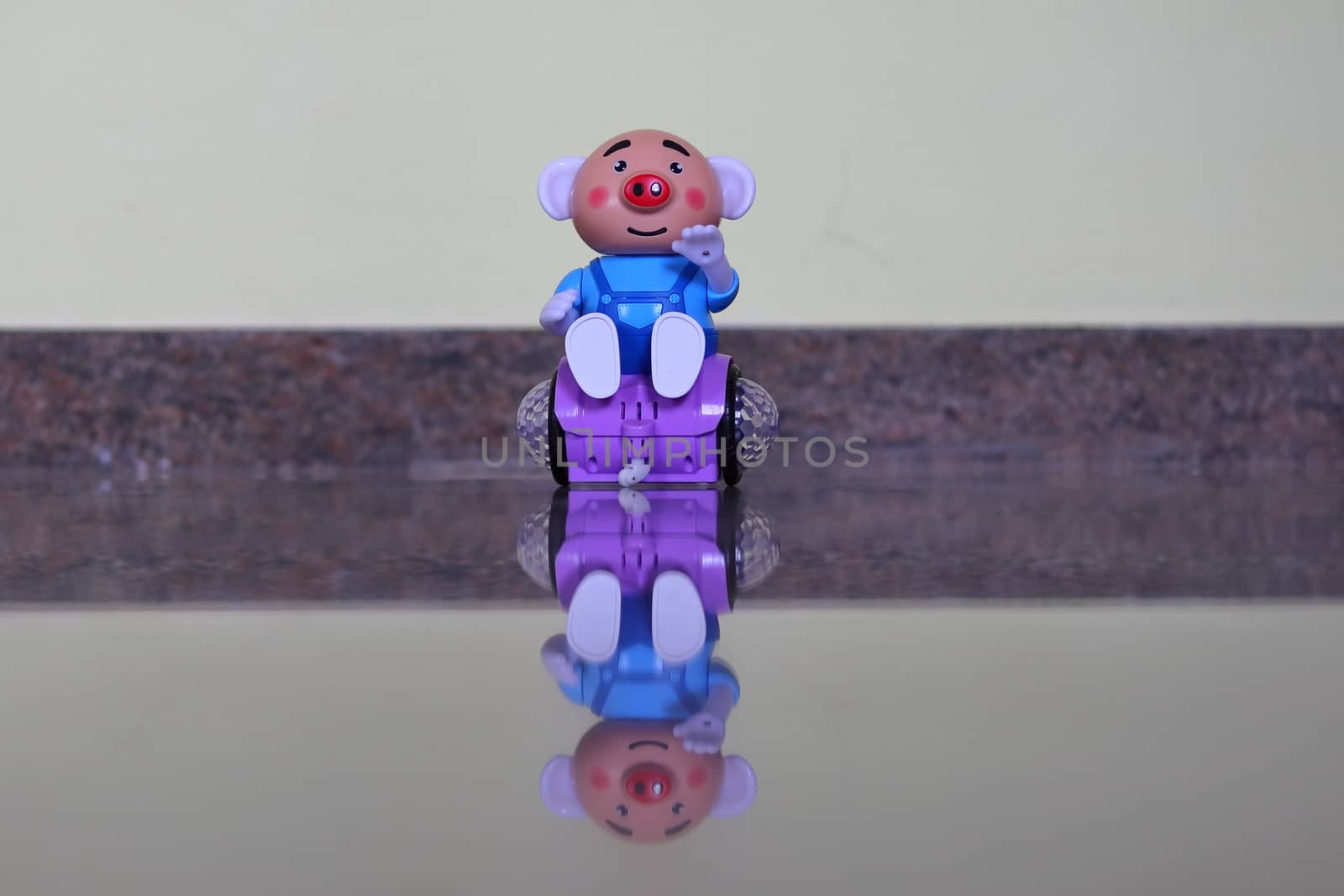 A picture of a child's toy on a transparent stone and a reflect image being made below it. (electronic robot )