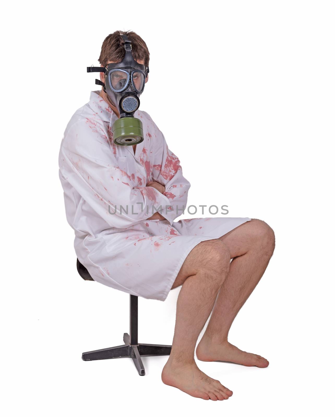 Man wearing gas mask and bloody doctors coat sitting on small chair, isolated