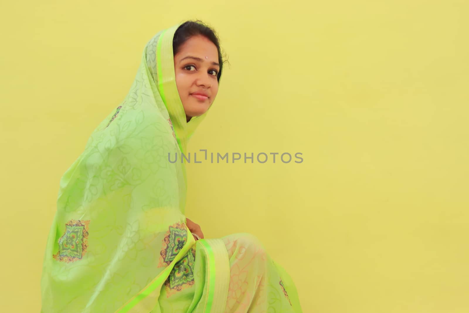 indoors portrait of young asian model on yellow background, saree design