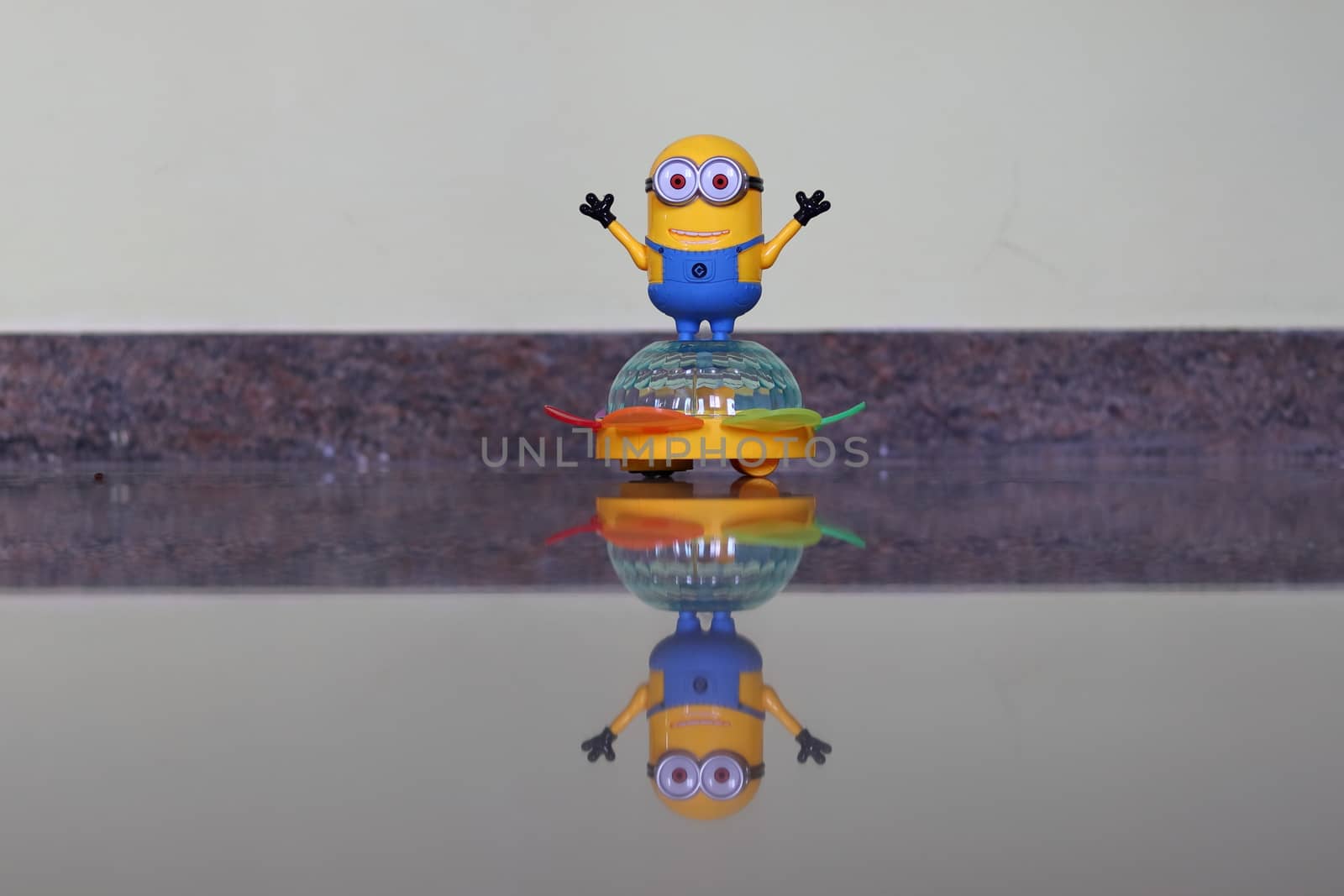 A picture of a child's toy on a transparent marble stone and a reflect image being made below it. (electronic robot )