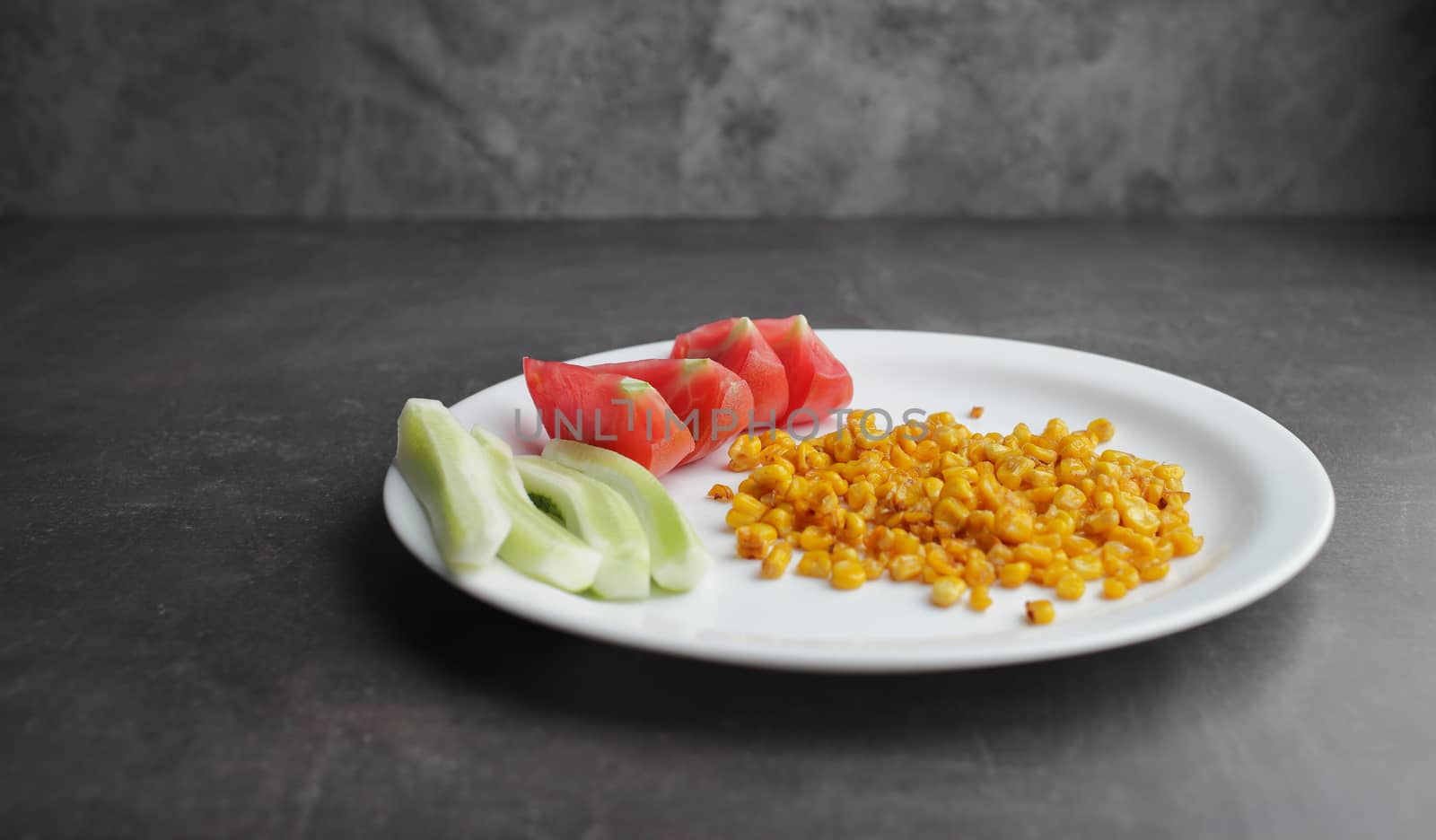 Diet. Organic Grilled Corn, tomato, cucumber on a white plate. Organic farm vegetables. Environmentally friendly products