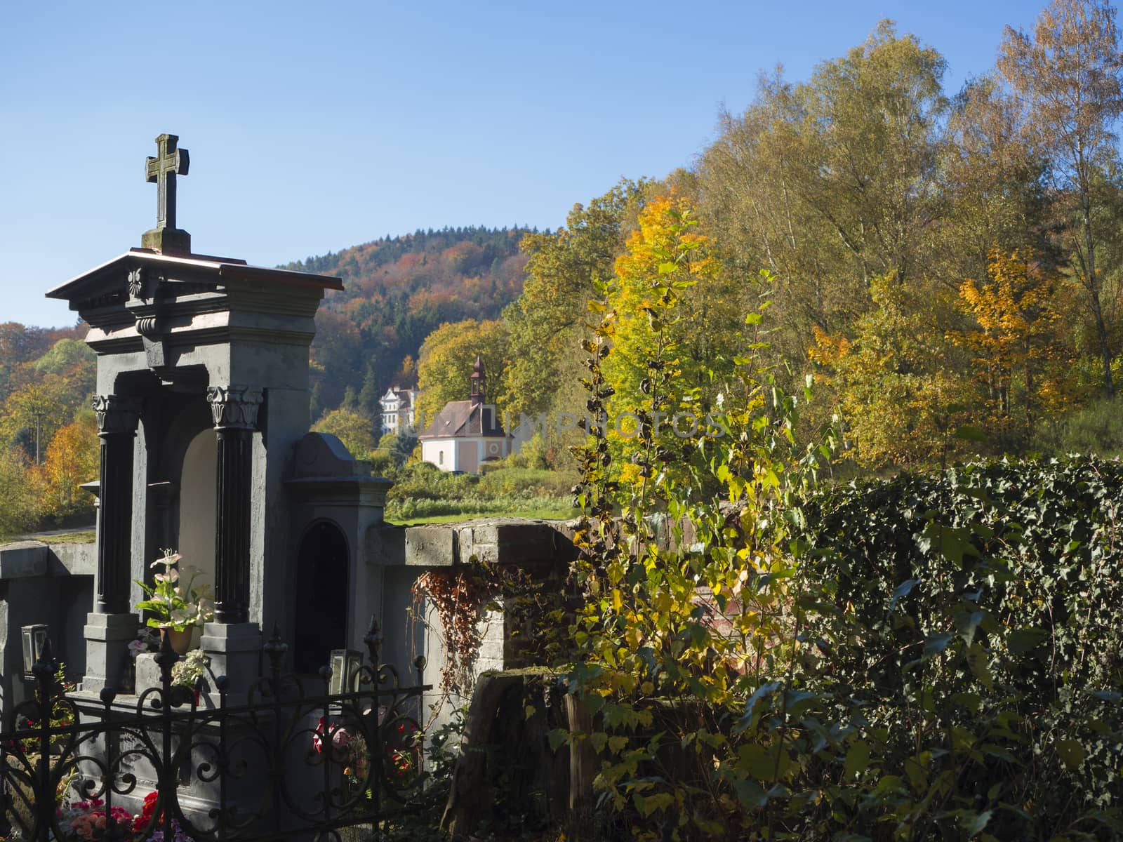 family vault tomb in village cemetery with view on autumn landscape and baroque chapel in luzicke hory in czech republic