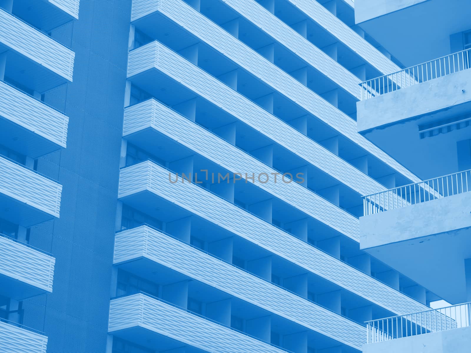 blue toned abstract image of large modern highrise modern apartment buildings with angular balconies