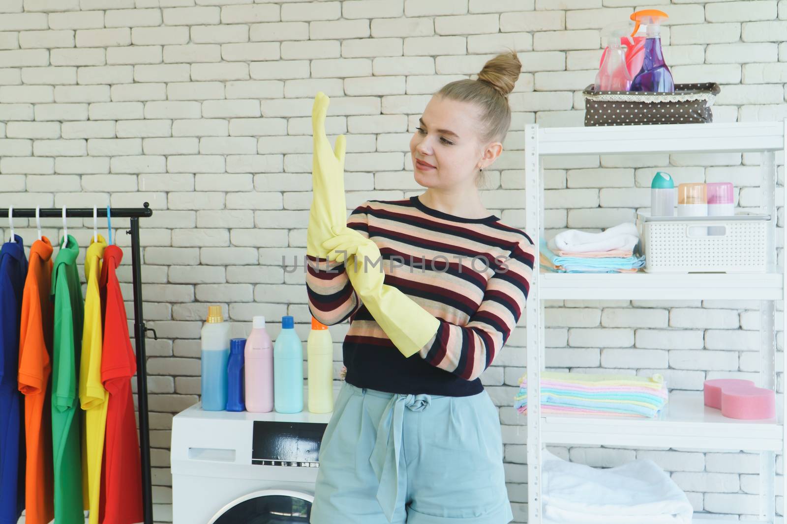 Beautiful young Caucasian women In casual wear, wearing yellow rubber gloves Prepare for laundry, clothes, and house cleaning. Attractive clean modern housekeeper, smiling and happy for the chore.