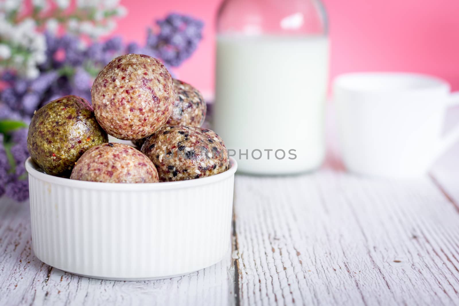 Healthy snack. Energy ball with date plam, black and white sesame, chia and rasin in ceramic bowl on wooden table. Vegan vegetarian.