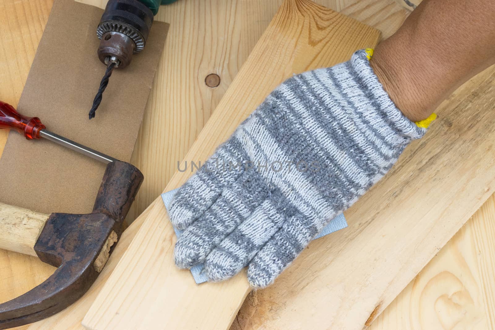 Worker Man Polishing Sandpaper Wood by hand.