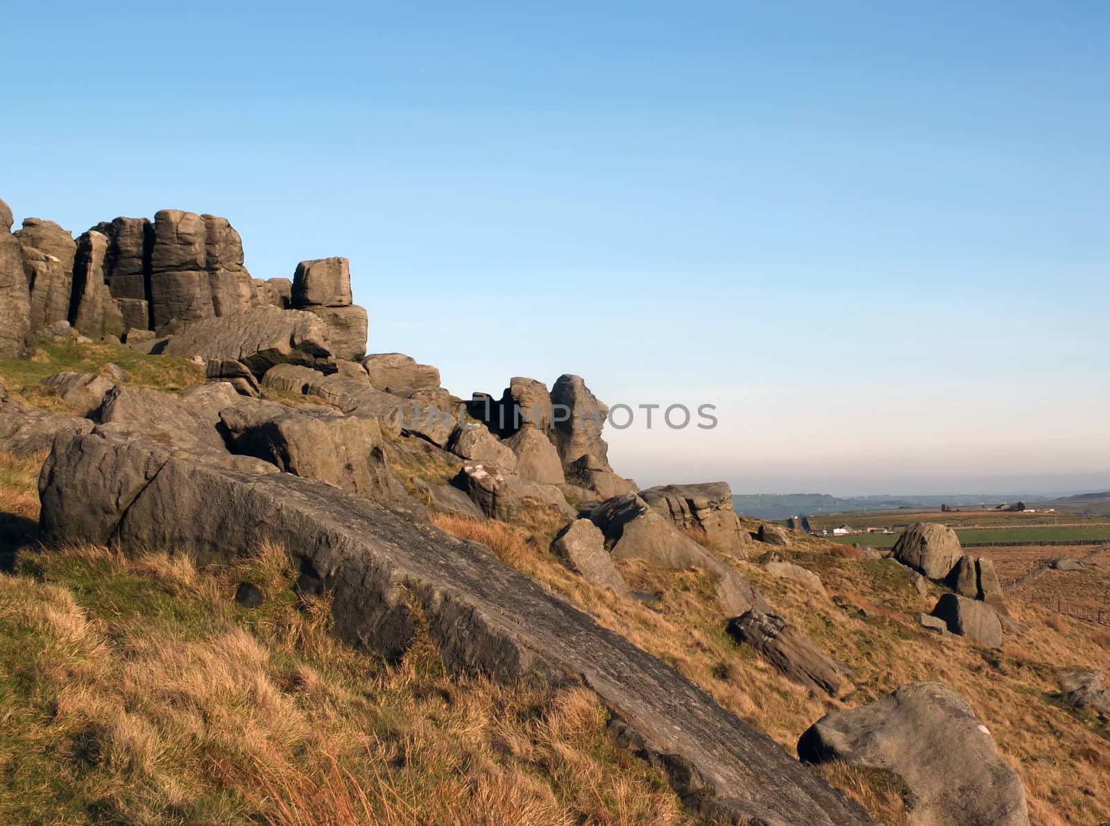 large rugged gritstone outcrop at the bridestones a large rock formation in west yorkshire near todmordenwith blue sky and surrounding countryside