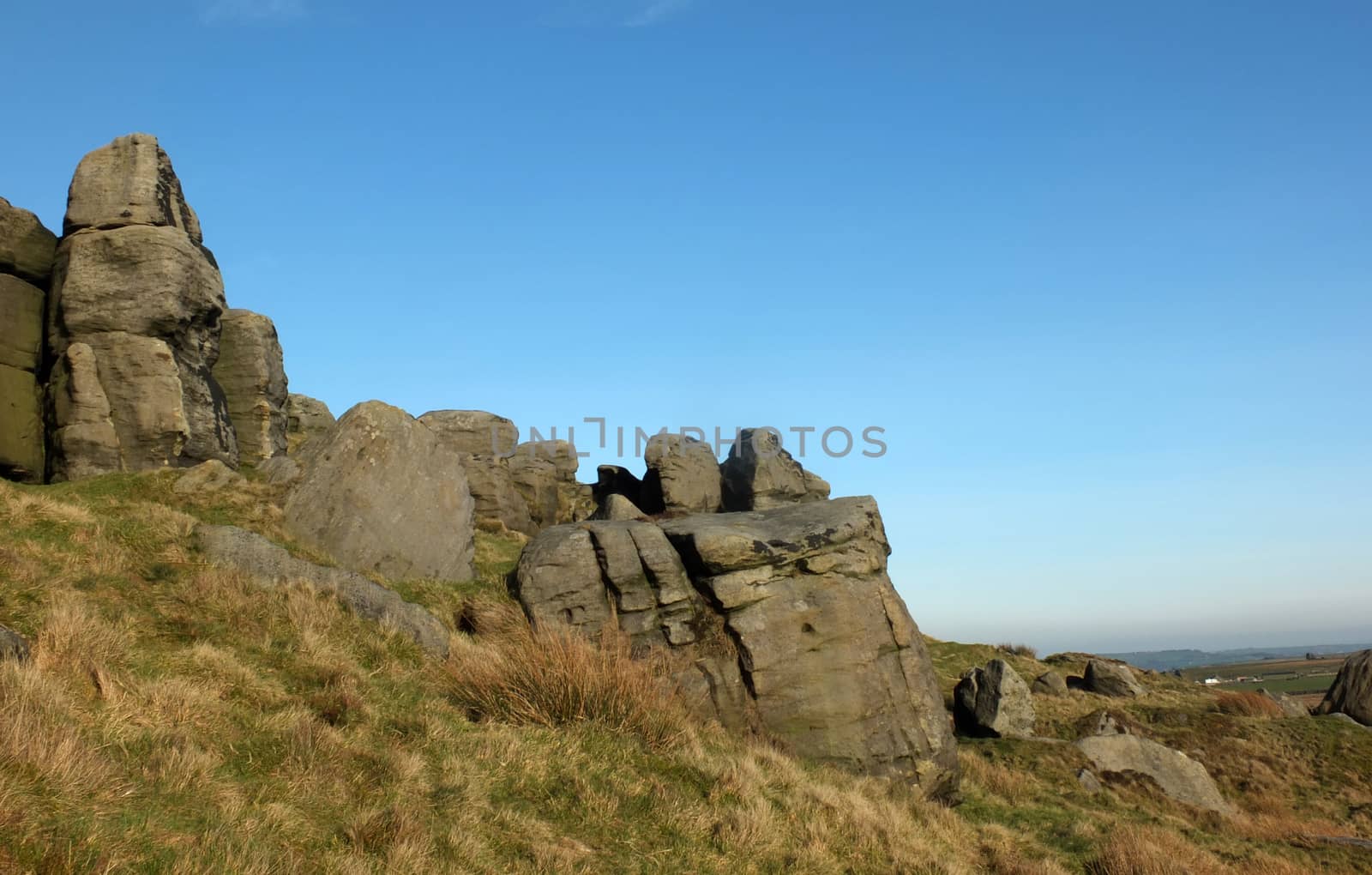 large rugged gritstone outcrop at the bridestones a large rock formation in west yorkshire near todmorden with blue sunlit sky