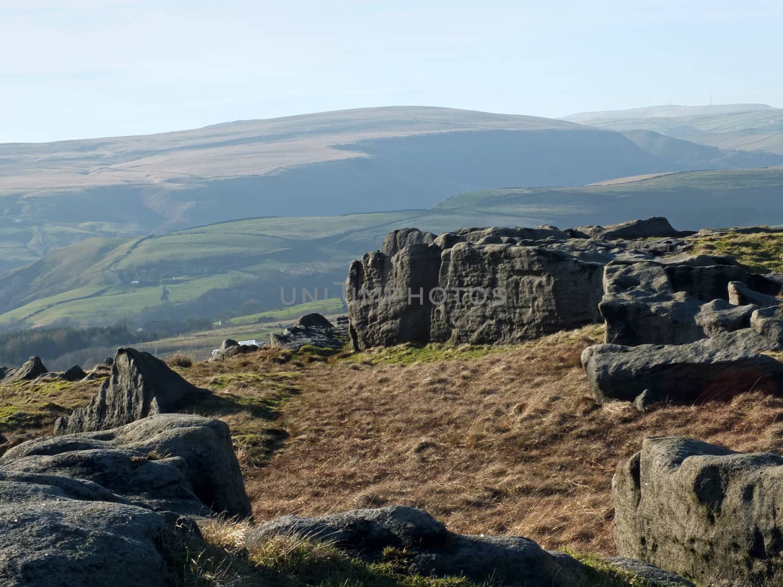 bridestones moor in west yorkshire with gritstone outcrops surrounded by hills on a sunny day