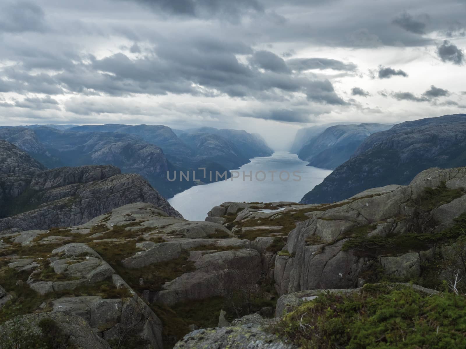 View on landscape with rock,blouders, stone and Lysefjord on hike to Preikestolen massive cliff famous Norway viewpoint Moody sky, autumn day. Nature and travel background, vacation and hiking holiday