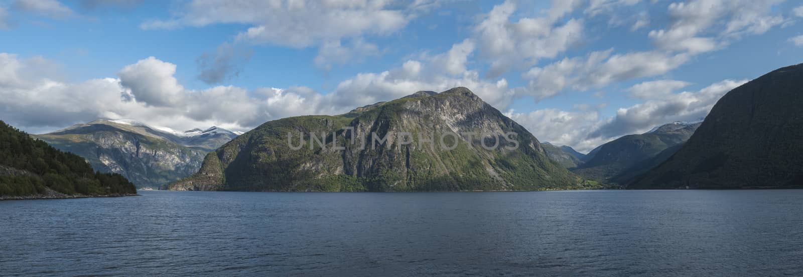 Beautiful Wide panoramic view on Norwegian fjord. View across Storfjorden, towards village Eidsdal. Summer, blue sky. Norway.