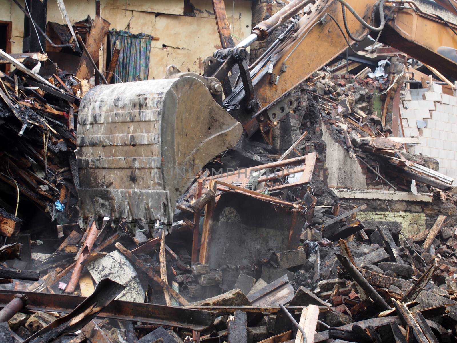 a hydraulic excavator machine working on a demolition site clearing debris