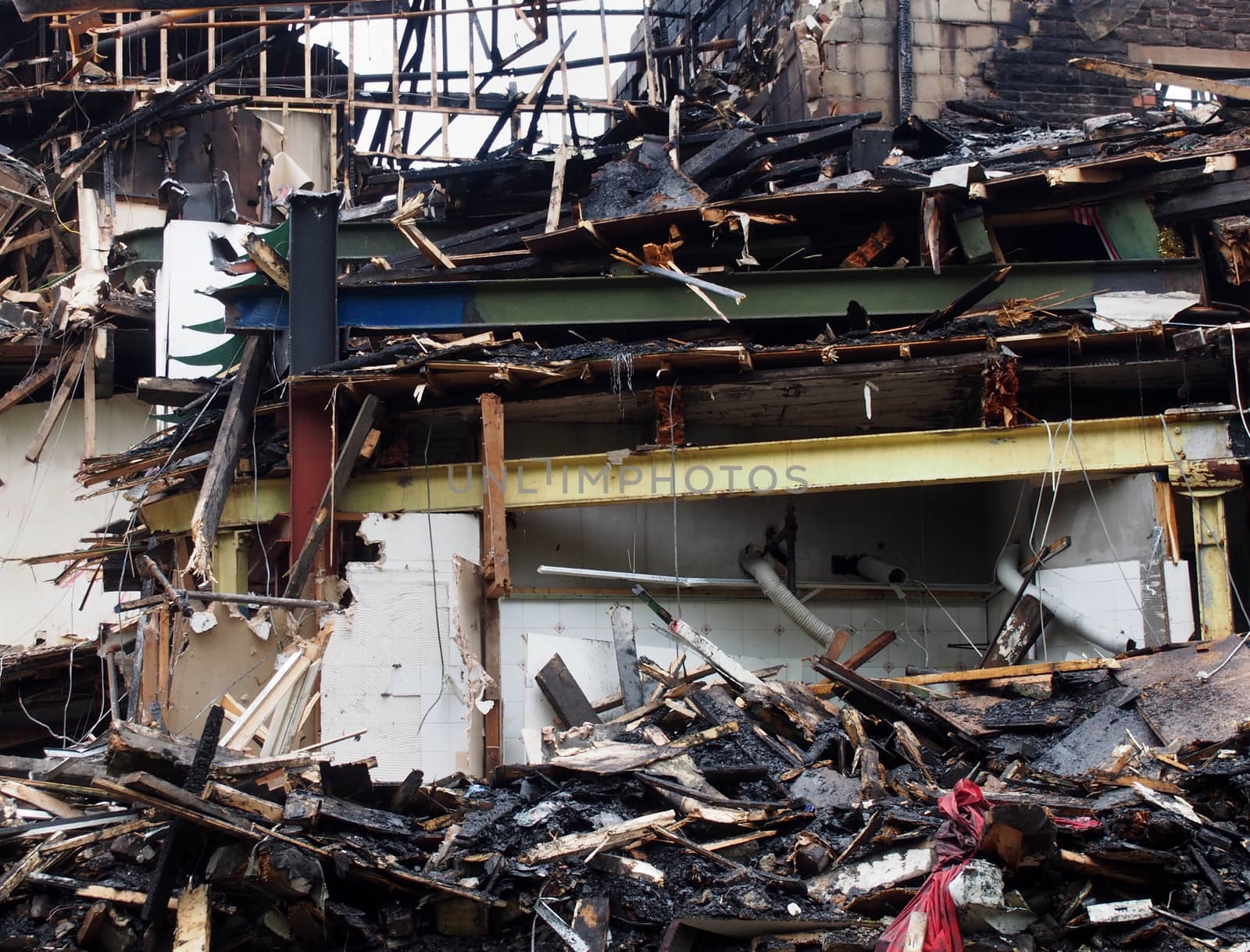black burned debris and timber and steel beams in a collapsed building destroyed by fire