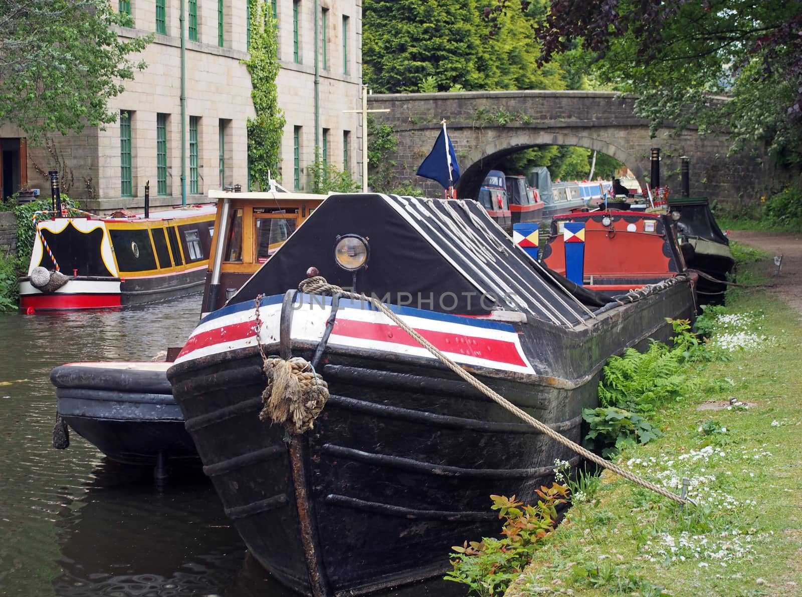 old barges and houseboats moored on the rochdale canal in hebden bridge in west yorkshire by philopenshaw
