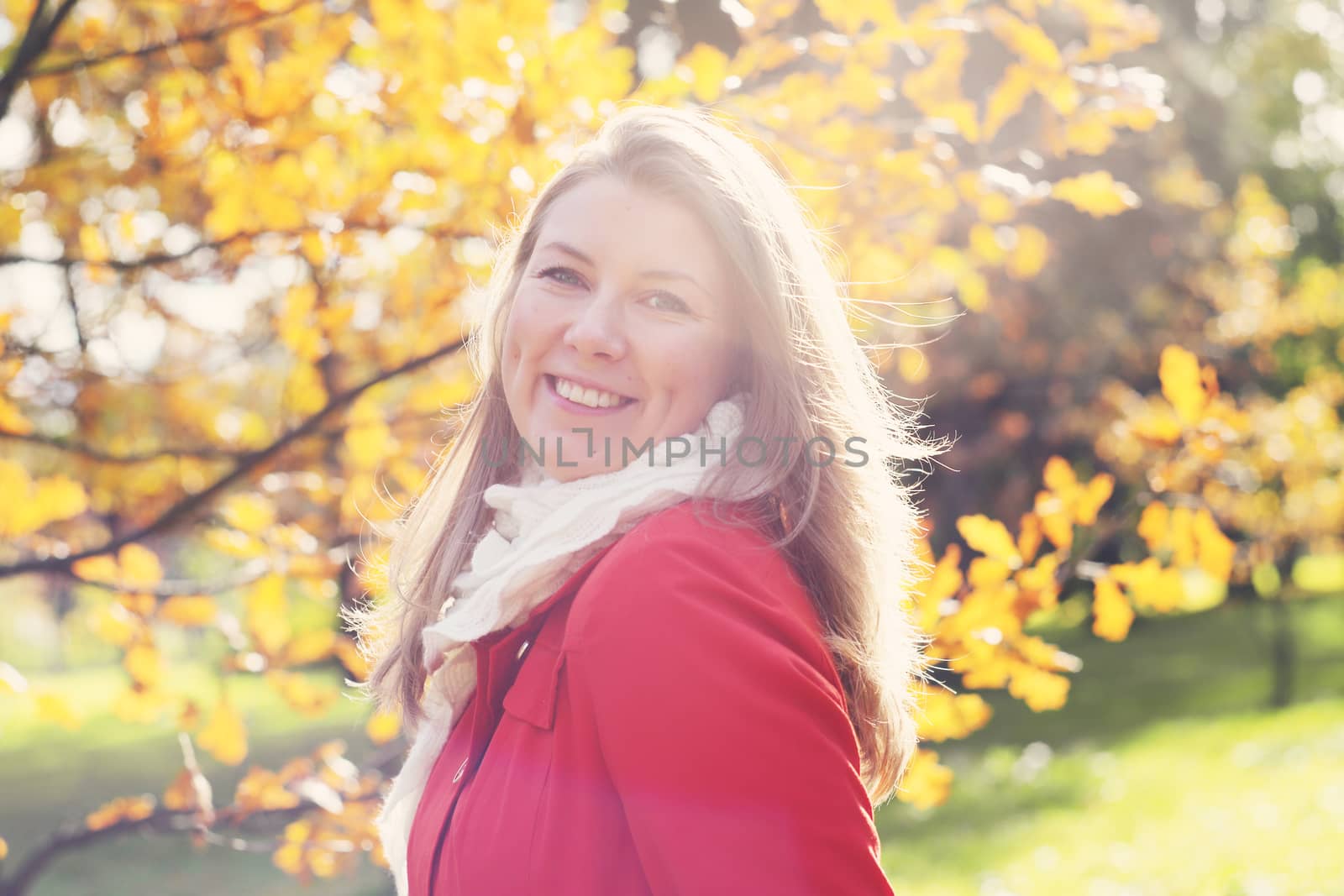 Portrait of young blonde cute woman smiling walking in autumn park
