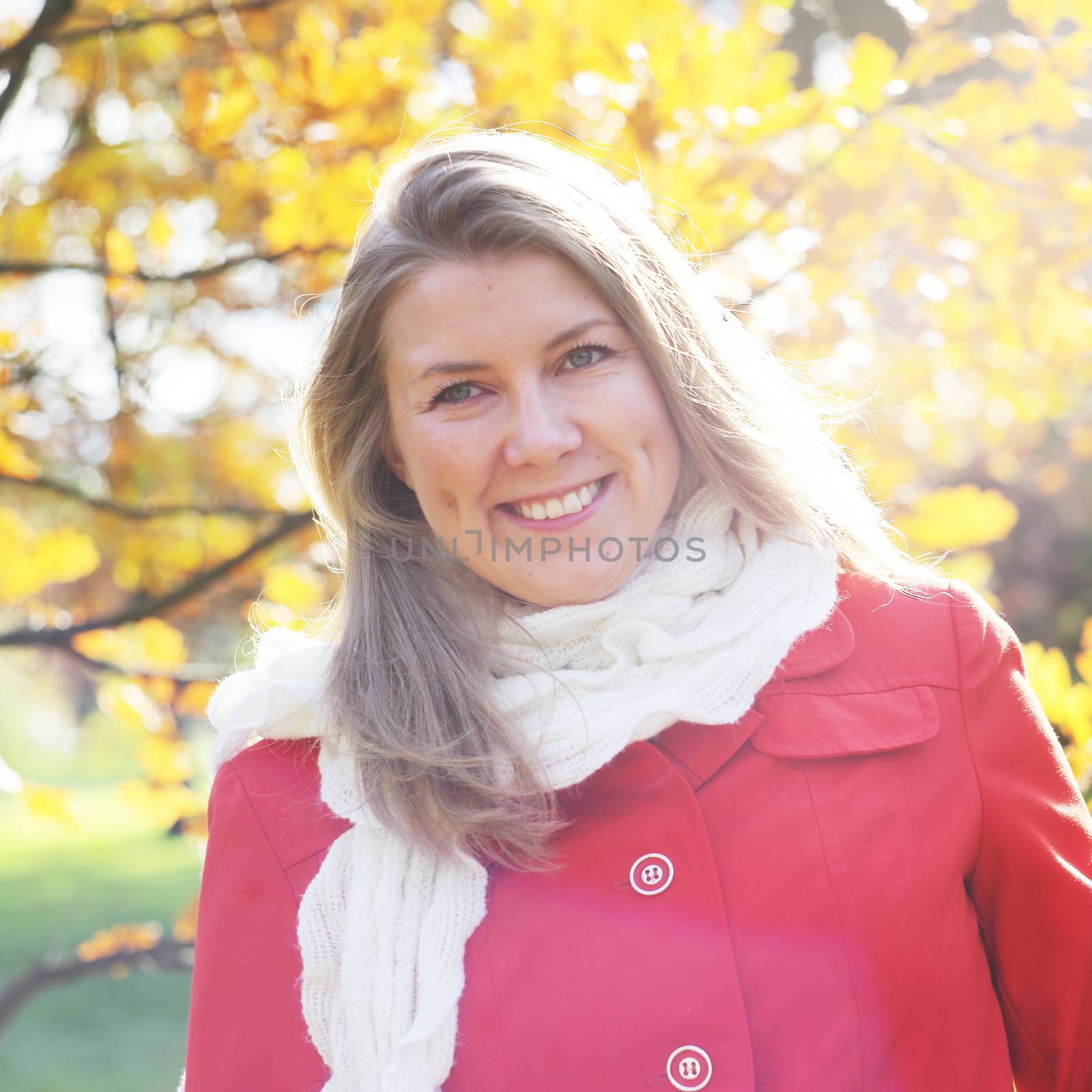 Portrait of young blonde cute woman smiling walking in autumn park