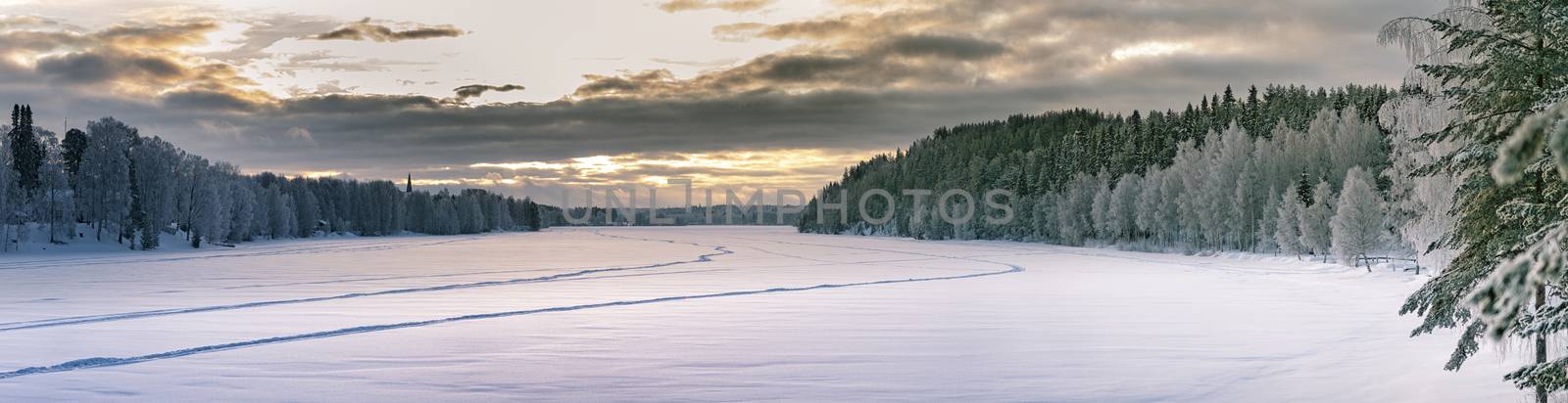 Sunset panorama over winter forest at sides and frozen river in the middle. Typical Northern Sweden landscape - birch and spruce tree covered by hoarfrost - very cold day, Lappland, Sweden