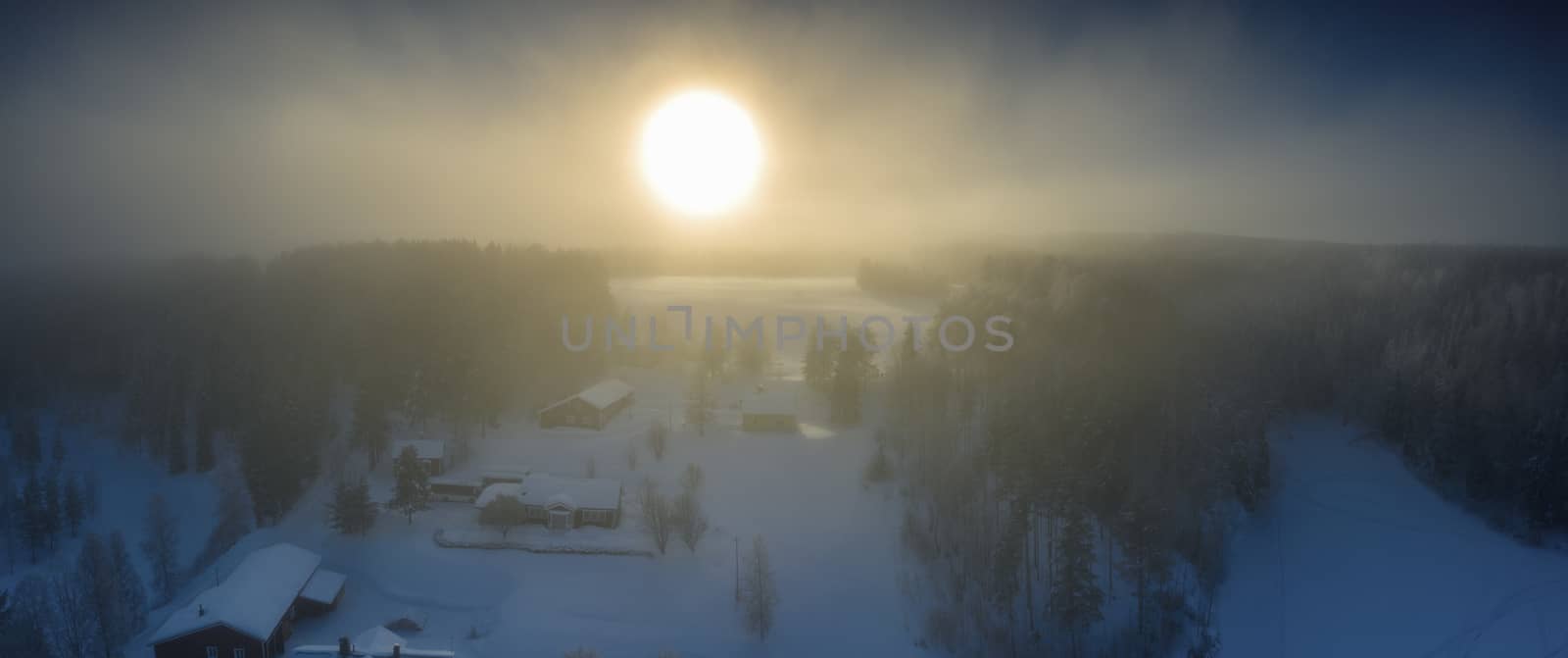 Majestic view of winter sunset with very large sun spot in frozen foggy air, winter pine tree forest, aerial, Grano village, around Umea city, Northern Sweden, short winter day, subarctic landscape. by skydreamliner