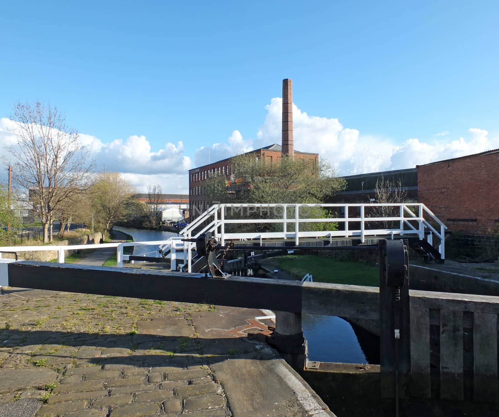 the historic castleton mill near armley in leeds and oddy lock gates and footbridge crossing the canal