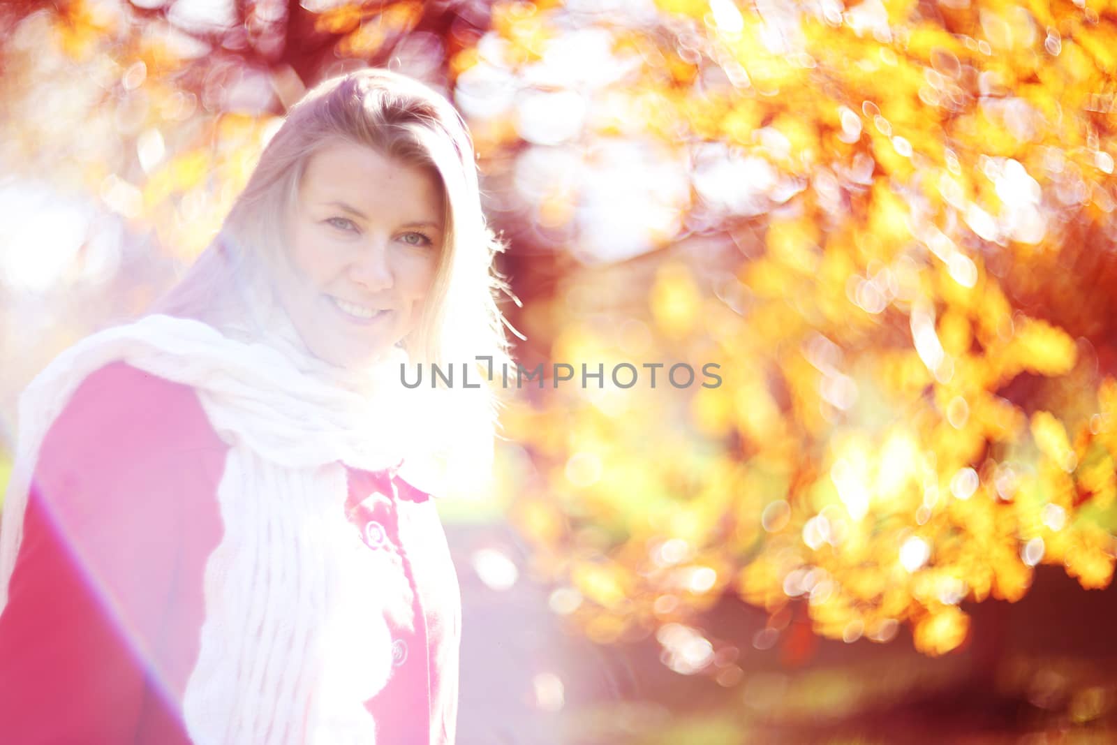 Portrait of young blonde cute woman smiling walking in autumn park