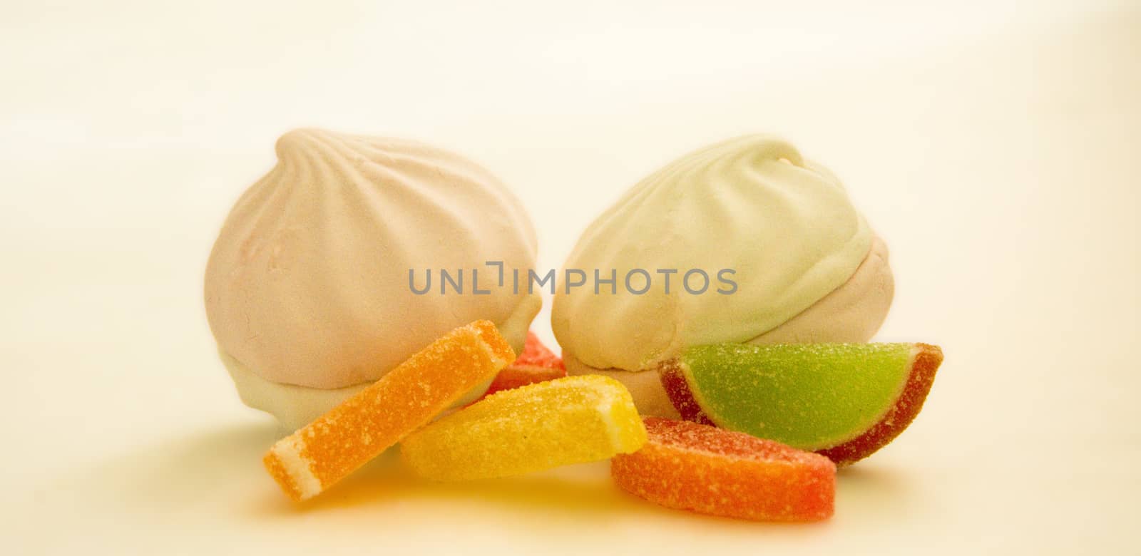 Fruit jelly slices and marshmallows on a white background