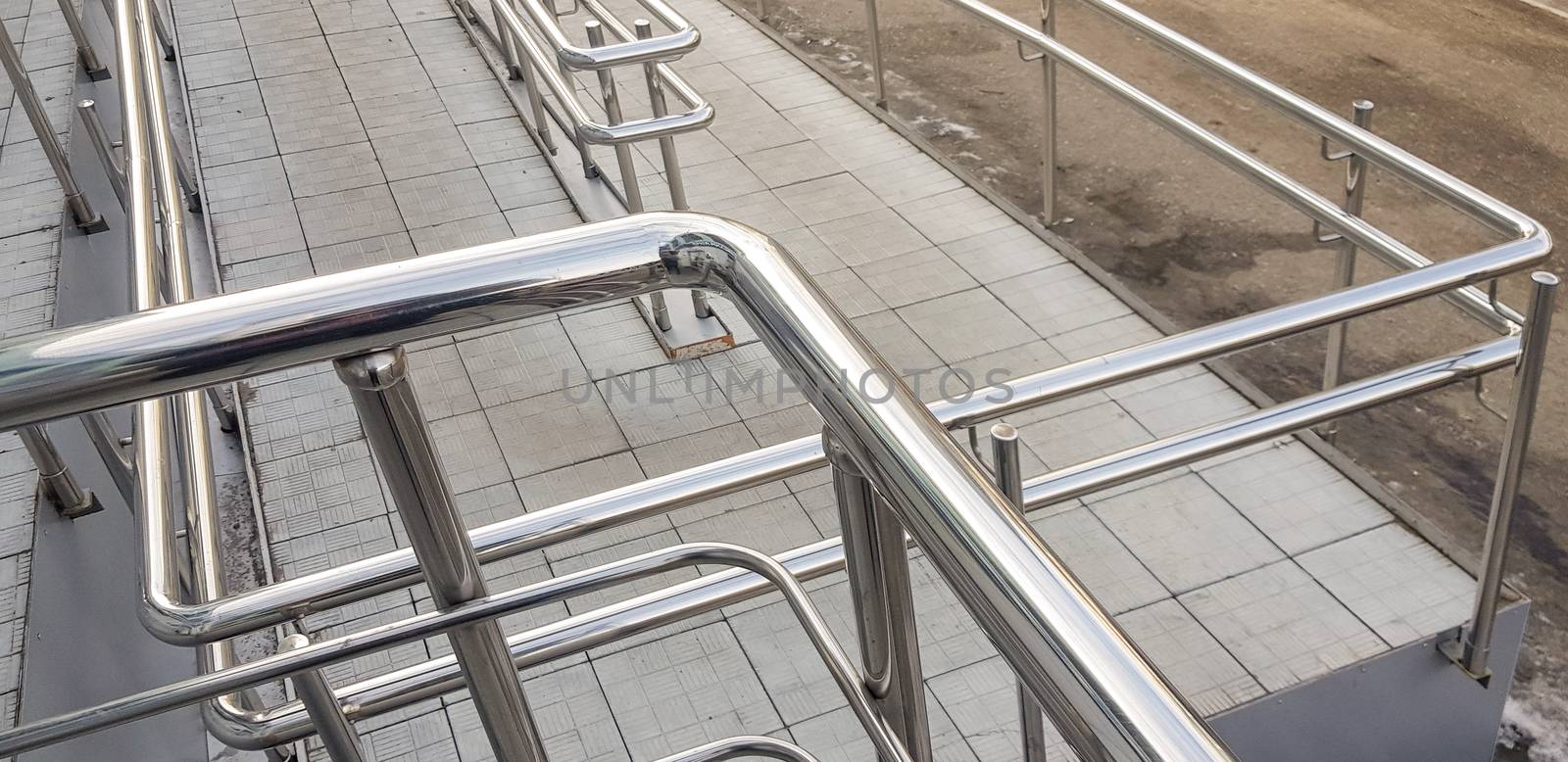 Close-up, entrance to the building with a wheelchair ramp and metal handrails, outdoor.