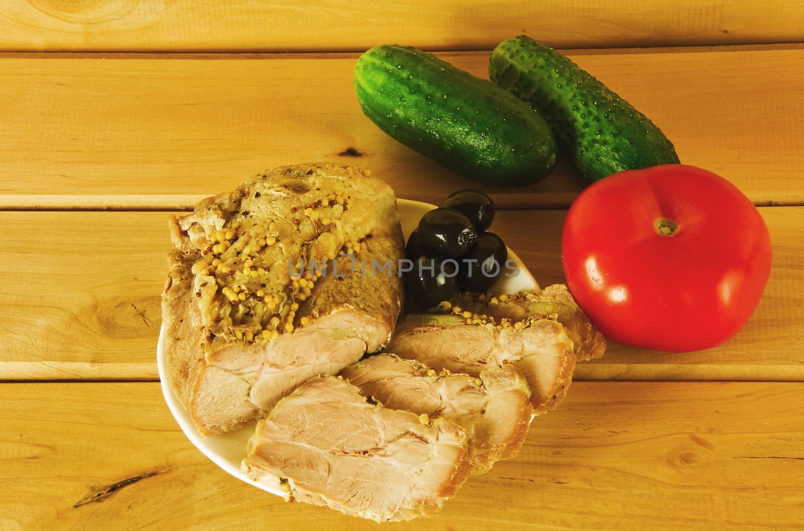 Baked ham on a plate on a wooden surface