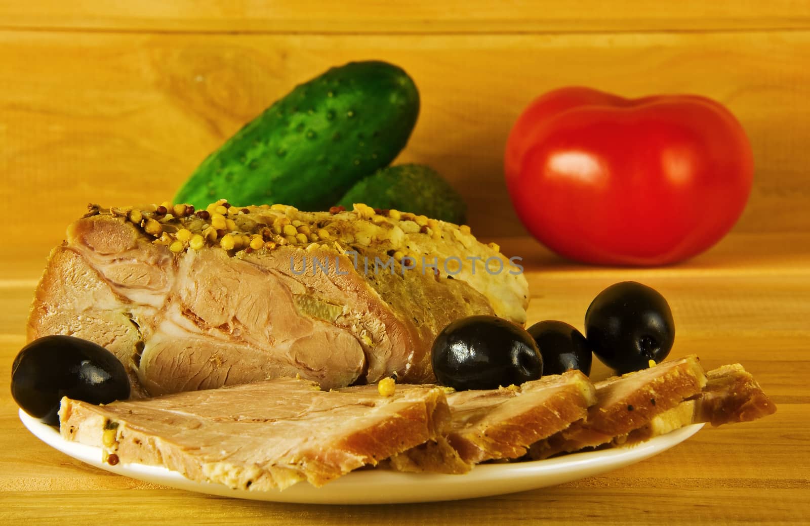 Baked ham on a plate on a wooden surface

