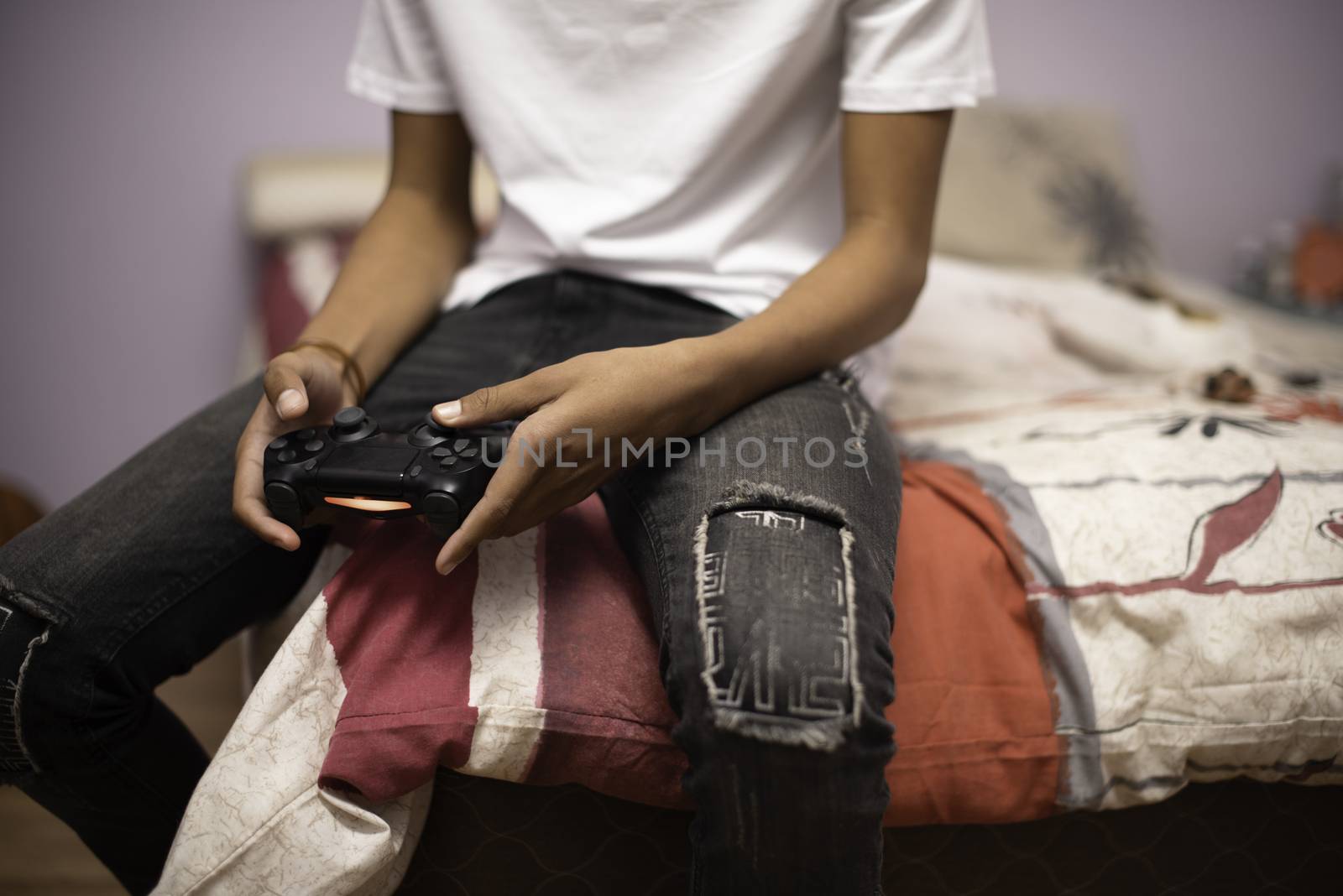 Teenager playing video games at home