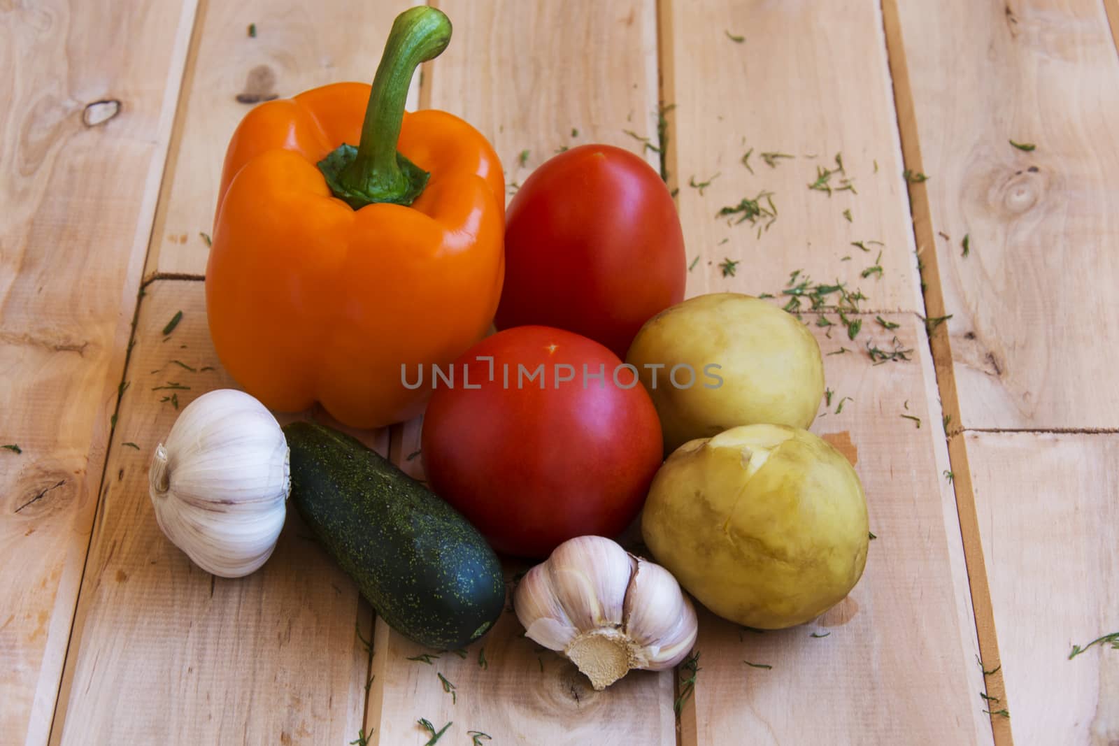 Potatoes, tomatoes, peppers, cucumbers and garlic on a wooden su by Grommik