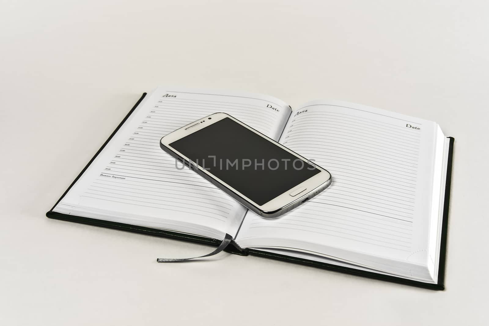 Open daily on white and lying on it a smartphone by Grommik